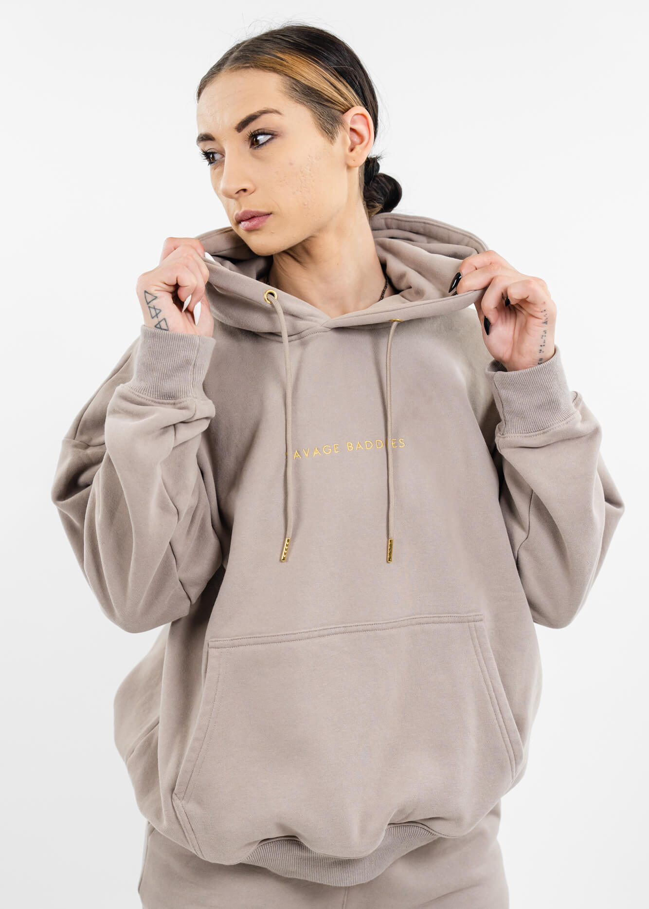 sexy female wearing oversized hoodie with gold accents and gold logo